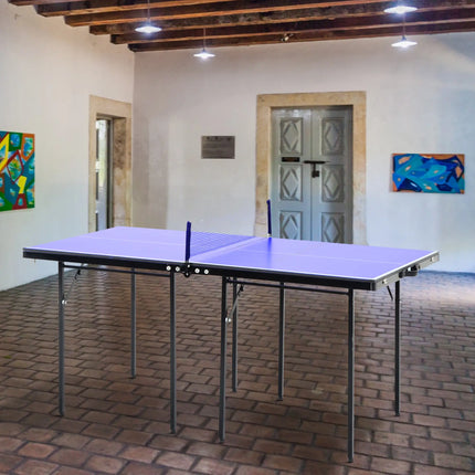 Foldable ping pong table with paddles and net set up indoors